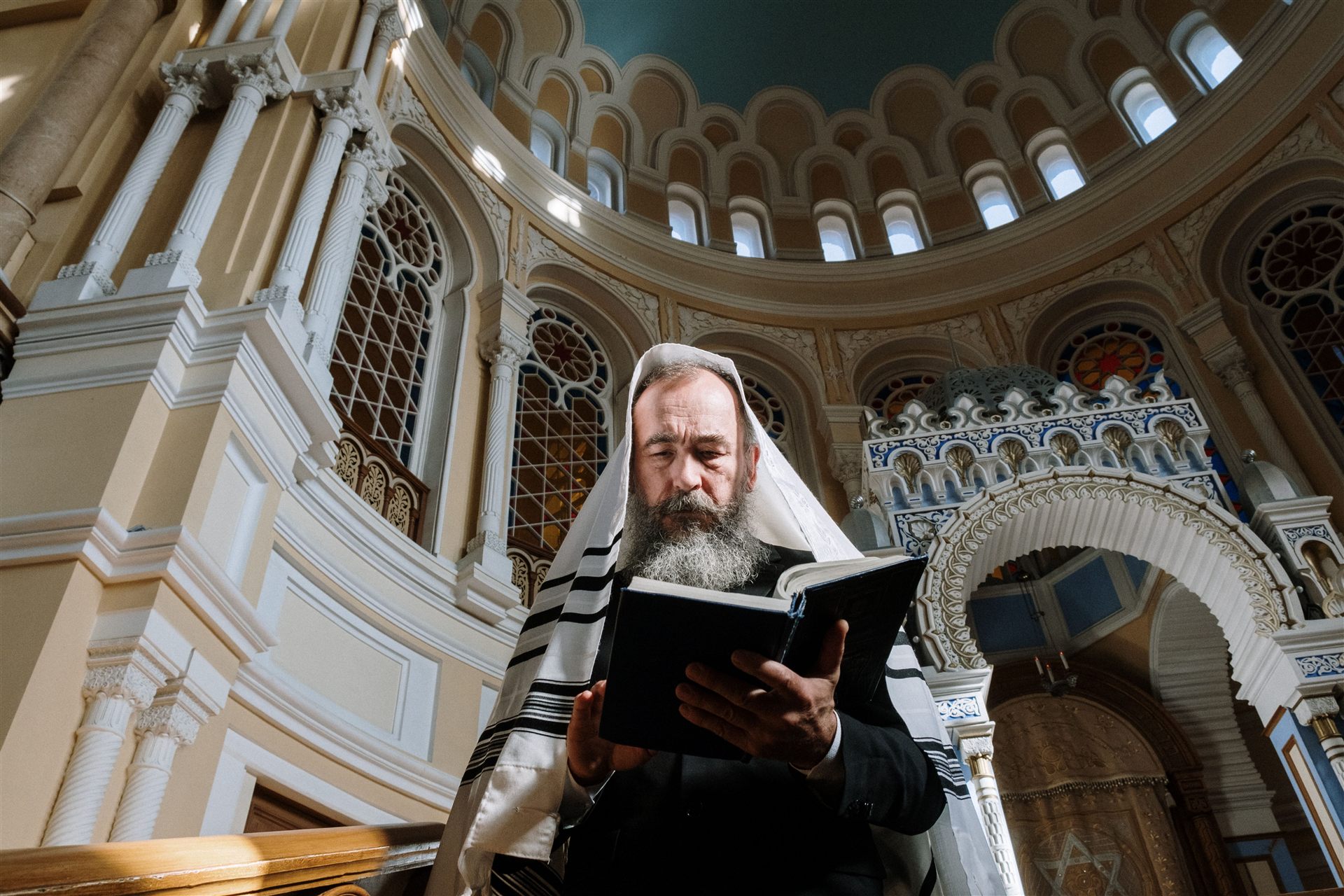 A rabbi or Jewish prayer leader with a Torah or prayer book